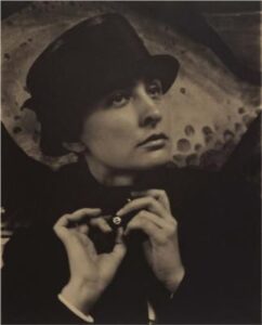 A monochrome photograph of Georgia O'Keeffe adorned with a fashionable hat, capturing a classic and sophisticated look.